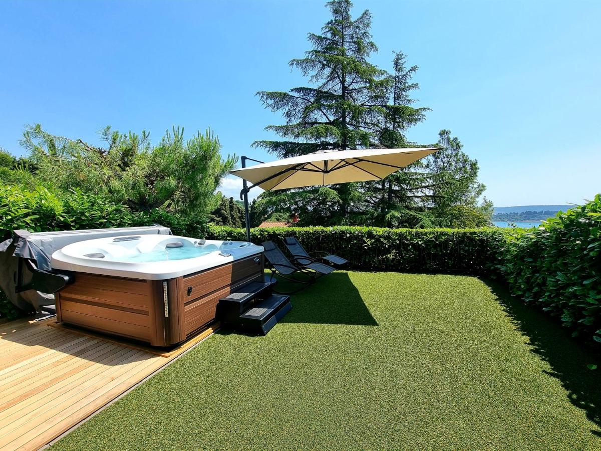 Jacuzzi pod senčnikom ob urejenem vrtu